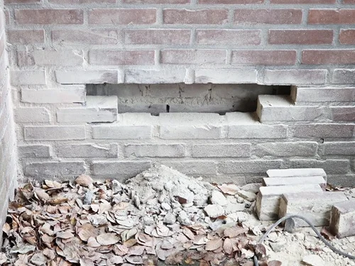 Een buitenmuur die open gemaakt is om spouvervuiling te verwijderen